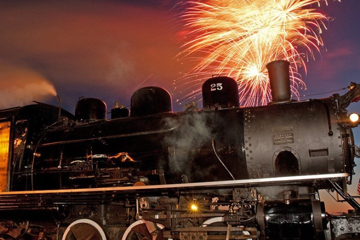 a steam engine is sitting on a train track