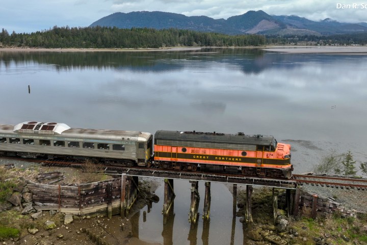 a train traveling down train tracks next to a body of water