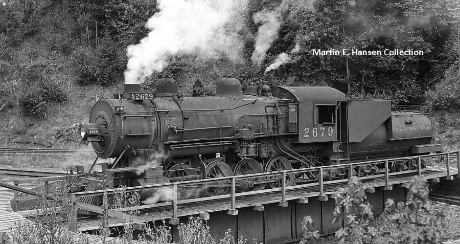 sp_2679salmonberryhhasmall_med_hr a steam engine is sitting on a train track with smoke coming from it